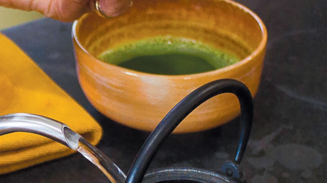 pour matcha green tea from a teapot into a cup